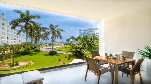 een eetkamer met een tafel en een groot raam bij Aria Ocean View Condo 206 by Kivoya in Nuevo Vallarta 