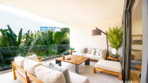 een woonkamer met witte meubels en een groot raam bij Aria Ocean View Condo 206 by Kivoya in Nuevo Vallarta 