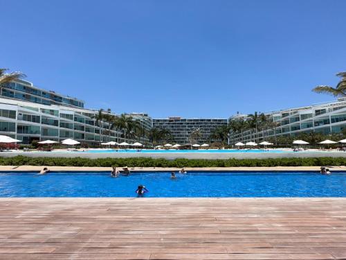 a large swimming pool with people in a resort at Aria Ocean View Condo 206 by Kivoya in Nuevo Vallarta 