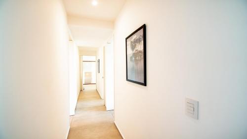 a hallway with white walls and a picture on a wall at Aria Ocean View Condo 206 by Kivoya in Nuevo Vallarta 