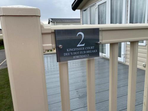 a sign on a fence in front of a house at KINGFISHER COURT 2 Tattershall lakes with hot tub in Tattershall