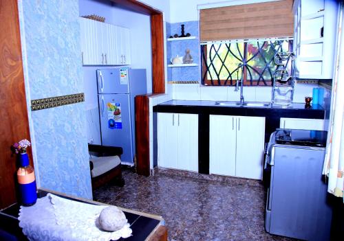 a kitchen with a sink and a refrigerator at Heavenly Royalz Farm Fortportal in Njara
