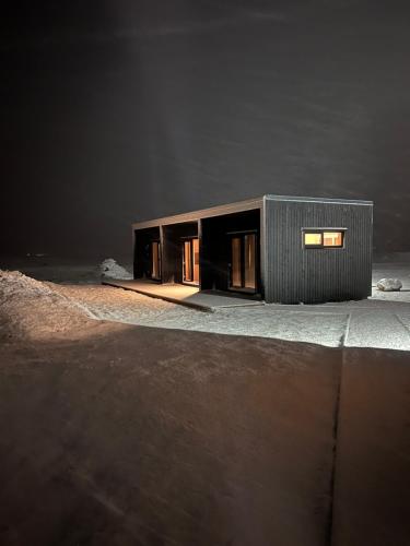 un pequeño edificio sentado en la parte superior de un estacionamiento en REY Stays - Small & Cozy Studio, en Höfn