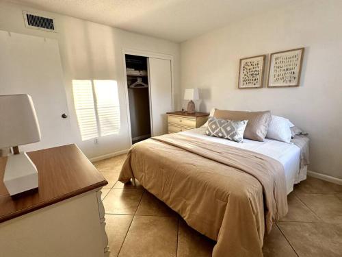 Schlafzimmer mit einem Bett, einem Tisch und einem Fenster in der Unterkunft Renovated Cozy Apartment in Naples (1.4 miles from the beach) in Naples