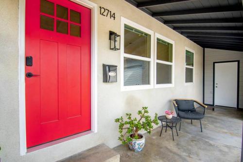 a red door on a house with a chair at Beautiful 3 Bed 1 Bath Designer Home + Hot Tub in North Hollywood