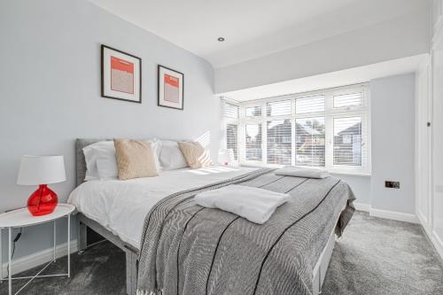 a white bedroom with a large bed and a window at Stylishly Decorated 3-bed House in Bedford