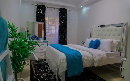 - une chambre avec un lit blanc et un miroir dans l'établissement Cade Homes 2, à Narok