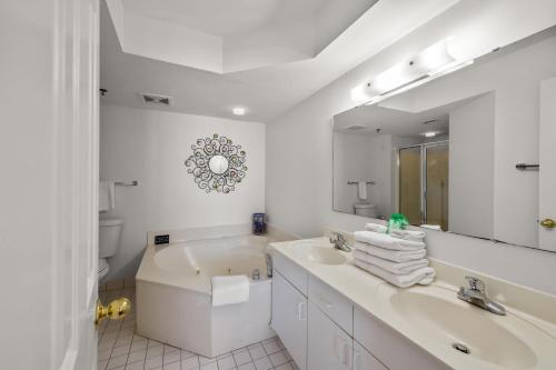 une salle de bain avec une baignoire, un lavabo et un miroir dans l'établissement Beach Club II 2E - Oceanfront - Windy Hill Section, à Myrtle Beach