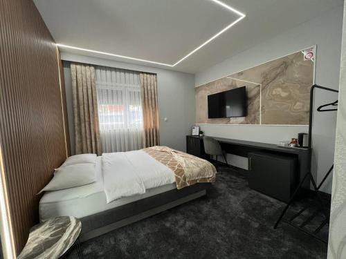Dormitorio con cama, escritorio y TV en Luxury Room 's en Velika Kladuša