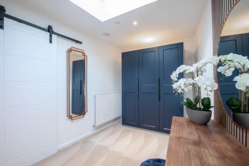 a hallway with blue doors and a table and flowers at Pittville Circus Road in Cheltenham