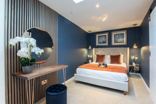 切爾滕納姆的住宿－Pittville Circus Road，一间拥有蓝色墙壁的卧室和一张带镜子的床