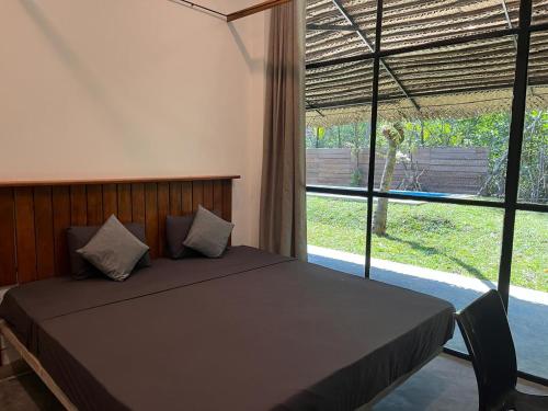a bedroom with a bed with a large window at VODA Hotel & Spa in Galle