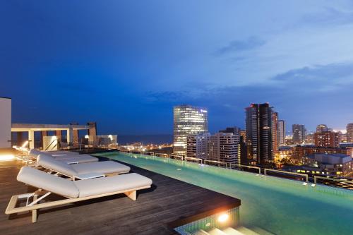 a rooftop pool with lounge chairs and a city skyline at Tembo Barcelona in Barcelona