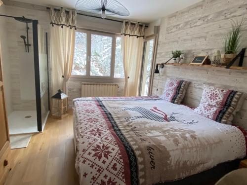 1 dormitorio con 1 cama con manta roja y blanca en LE VERTBRUCHE - Gîte avec superbe vue pour 15 pers, en La Bresse