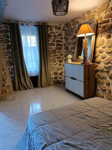 une chambre avec un lit et une commode avec un miroir dans l'établissement Paisible et cosy, à Ria