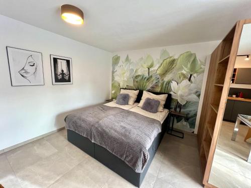 a bedroom with a bed with a plant on the wall at Ferienwohnung im Odenwald in Limbach