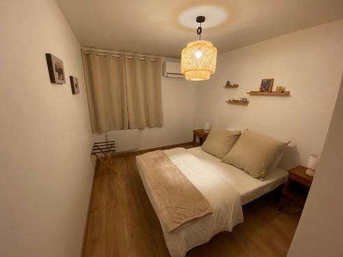 une chambre avec un lit et un lustre dans l'établissement Appartement Le Clos Fleuri 1, à Sixt-Fer-à-Cheval