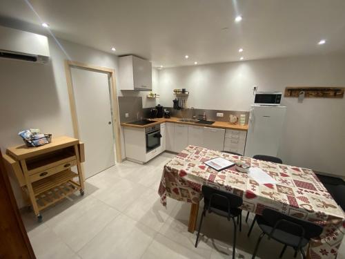 une cuisine avec une table, des chaises et une table. dans l'établissement Appartement Le Clos Fleuri 1, à Sixt-Fer-à-Cheval