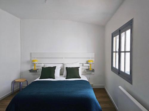 a bedroom with a large bed with two green pillows at L'Idrac, Appartements en Hyper centre in Toulouse