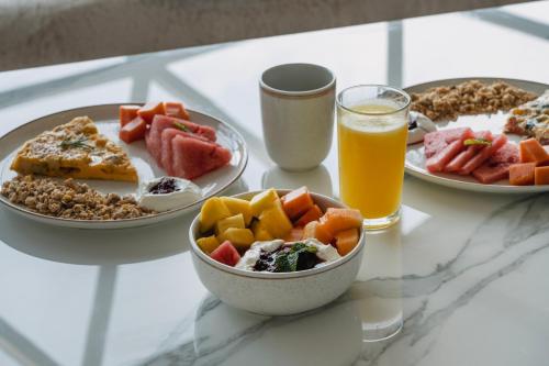 a table with plates of food and a glass of orange juice at Terramia Estate in Minca