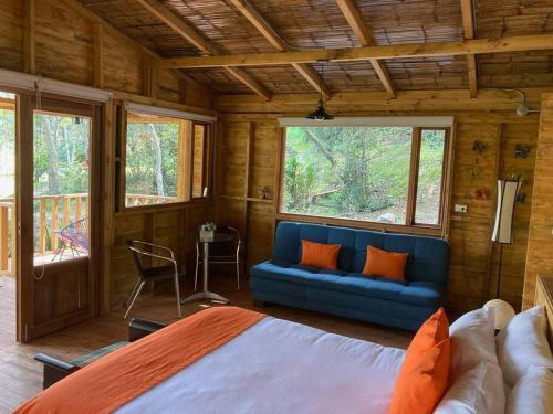 a bedroom with a blue bed and a couch at Cabaña en Villa de Leyva Se Permiten Mascotas Pet Friendly in Villa de Leyva