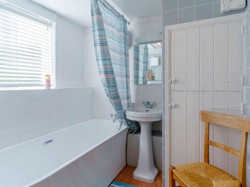 a bathroom with a tub and a sink and a toilet at 4 Bed in Llangynidr BN305 in Llangynidr