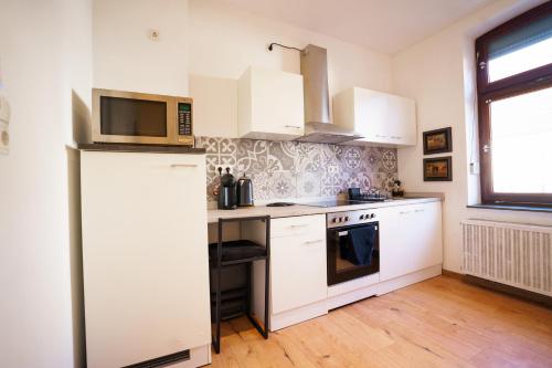 a kitchen with white cabinets and a refrigerator at Moselzauber Güls in Koblenz