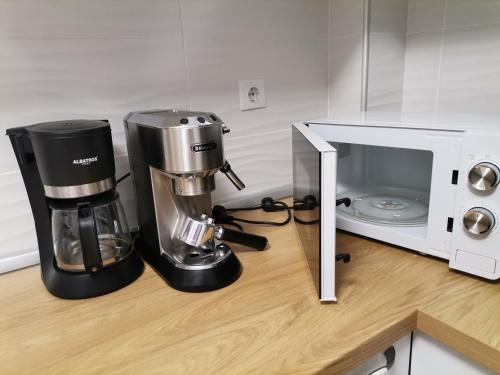 a kitchen counter with a coffee maker next to a microwave at Apartament Rubin in Sibiu