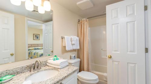 a bathroom with a sink and a toilet and a mirror at Ocean Bay Club 101 - Oceanfront - Ocean Drive Section in Myrtle Beach