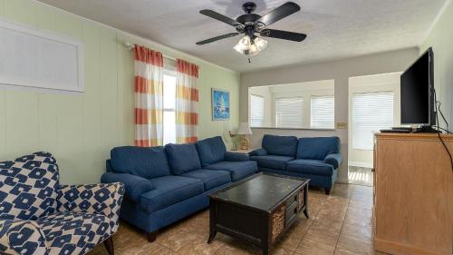 a living room with blue couches and a ceiling fan at High Tide - 3rd Row - Crescent Beach Section in Myrtle Beach