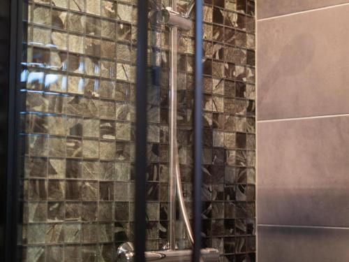 a shower in a bathroom with a brick wall at Wellness Home w Hot Tub in Hoenderloo