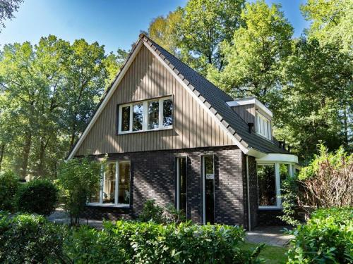 a house with a gambrel roof at Spacious Villa in Hoenderloo in Hoenderloo
