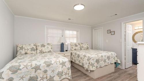 a bedroom with two beds and a table with a lamp at Sand Dollar - 3rd Row - Ocean Drive Section in Myrtle Beach
