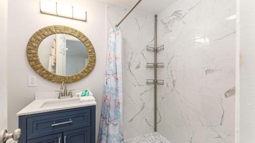 a bathroom with a shower and a sink and a mirror at Sand Dollar - 3rd Row - Ocean Drive Section in Myrtle Beach