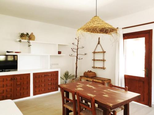 a dining room with a wooden table and a tv at Appartamentos Michel Dos in Sant Ferran de Ses Roques