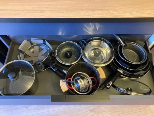 a drawer with a bunch of pots and pans at Comfort and tranquility near Lyon and Groupama Stadium, 4 personnes in Meyzieu