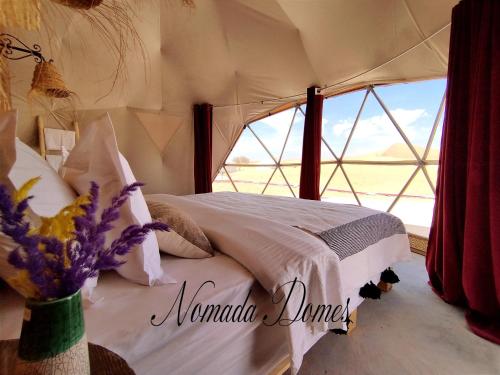 a bedroom with a bed in a tent at Nomada Domes in Merzouga