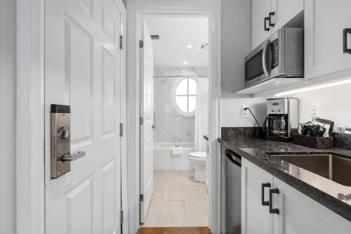 cocina blanca con lavabo y aseo en Touchstone Resort, en Bracebridge