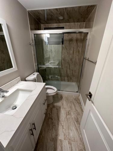 a bathroom with a shower and a toilet and a sink at Treasure’s Beautiful Basement in Brampton