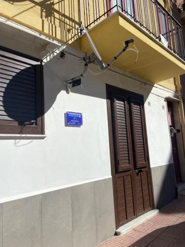 ein Gebäude mit einer Tür und einem Balkon in der Unterkunft Ferienhaus Marlene - Casa Vacanze San Nicola L'Arena in Trabia