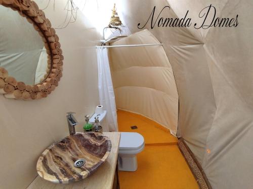 a bathroom with a sink and a toilet in a tent at Nomada Domes in Merzouga