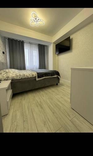 a bedroom with a bed and a ceiling fan at AIRPORT-TAXI-PARKING-Card in Chişinău