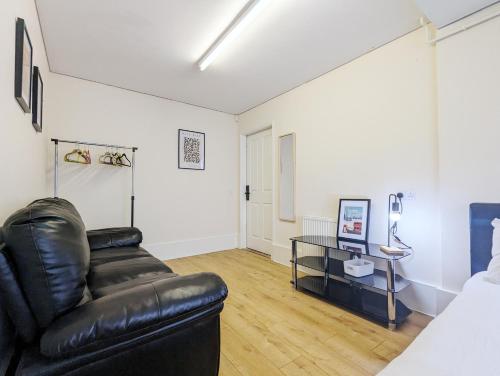 a living room with a leather couch and a table at Guest Rooms Near City Centre & Dock Free Parking in Liverpool