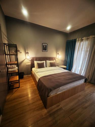 1 dormitorio con 1 cama grande y cortinas azules en Hotel Classic Corner en Tiflis