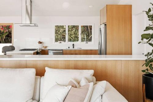 a kitchen with a couch and a kitchen with a refrigerator at The Broad Beach House in Malibu