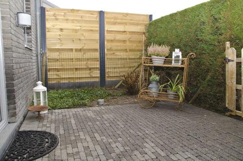 a garden with a cart with plants and a fence at Hotel Apartments Belgium 1 - HAB 1 in Geel