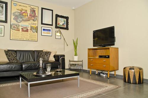 a living room with a couch and a tv at Hotel Apartments Belgium 1 - HAB 1 in Geel
