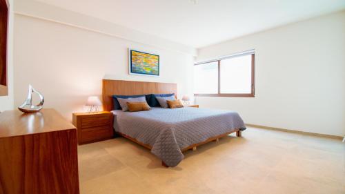 a white bedroom with a bed and a window at Casa del Mar by Kivoya in Bucerías