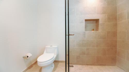 a bathroom with a toilet and a glass shower at Casa del Mar by Kivoya in Bucerías