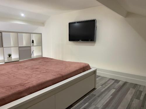 une chambre avec un lit avec une télévision à écran plat au mur dans l'établissement Jolie studio Nice Magnan, à Nice